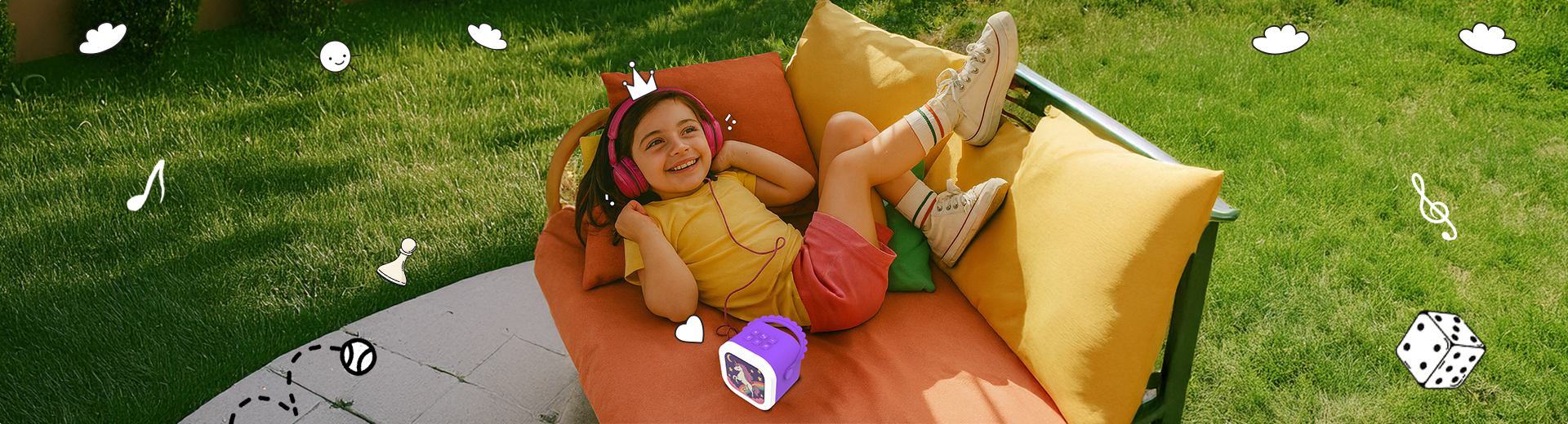 A child relaxing on a couch in a grassy field, listening to audio stories and songs on their Wonderbuddy player